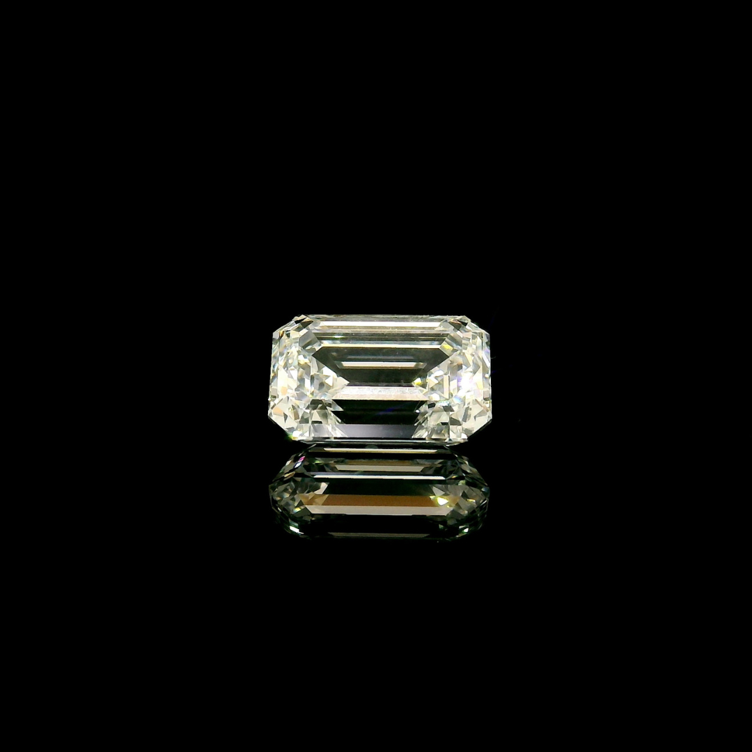 A 2 ct. Emerald Cut Lab Grown Diamond reflecting on a black surface.