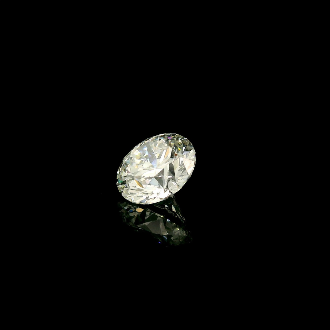 A 2 ct. Round Cut Lab Grown Diamond reflecting on a black surface.