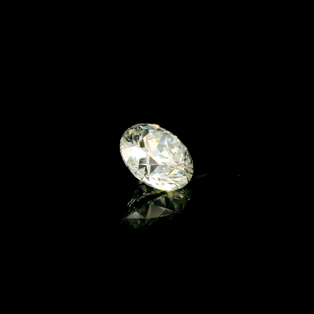 A 2 ct. Round Cut Lab Grown Diamond reflecting on a black surface.