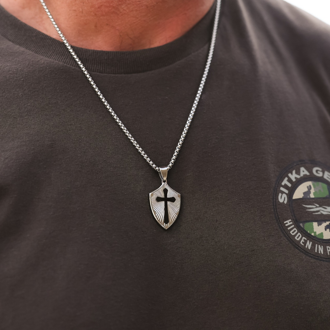 The David is a silver shield necklace featuring a pendant with a cutout cross design.