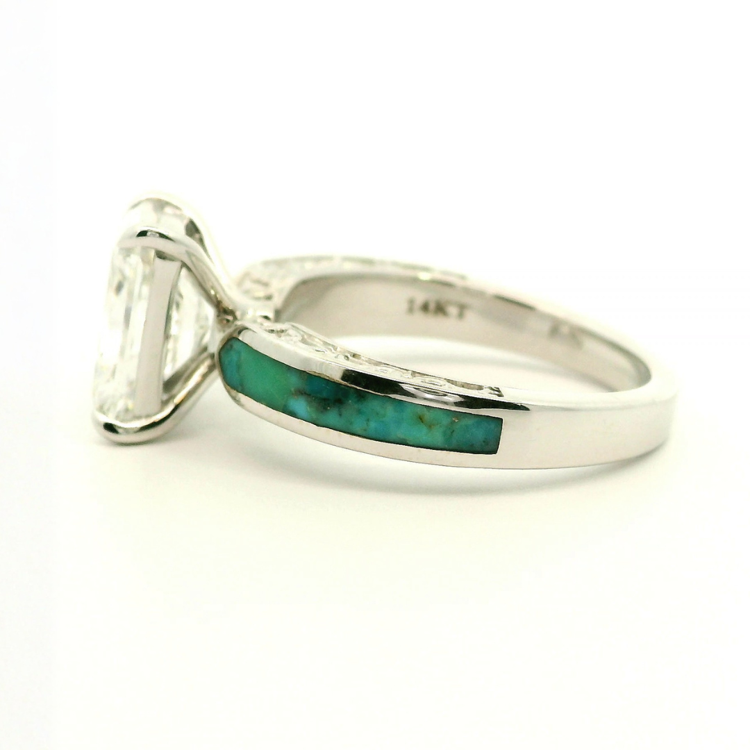 Introducing the Diamond Rochelle: a silver ring adorned with an emerald-cut lab-grown diamond and accented by a turquoise inlay on the band. The inner band is stamped 14KT, denoting 14 karat gold. Photographed on a plain white background.