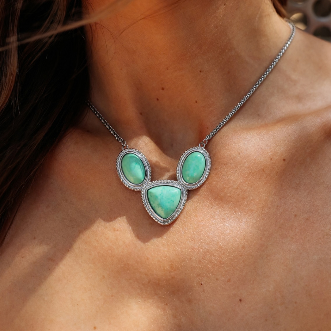 The Eve is a silver Western necklace featuring three light green, rounded triangular stones with delicate silver rope detailing.