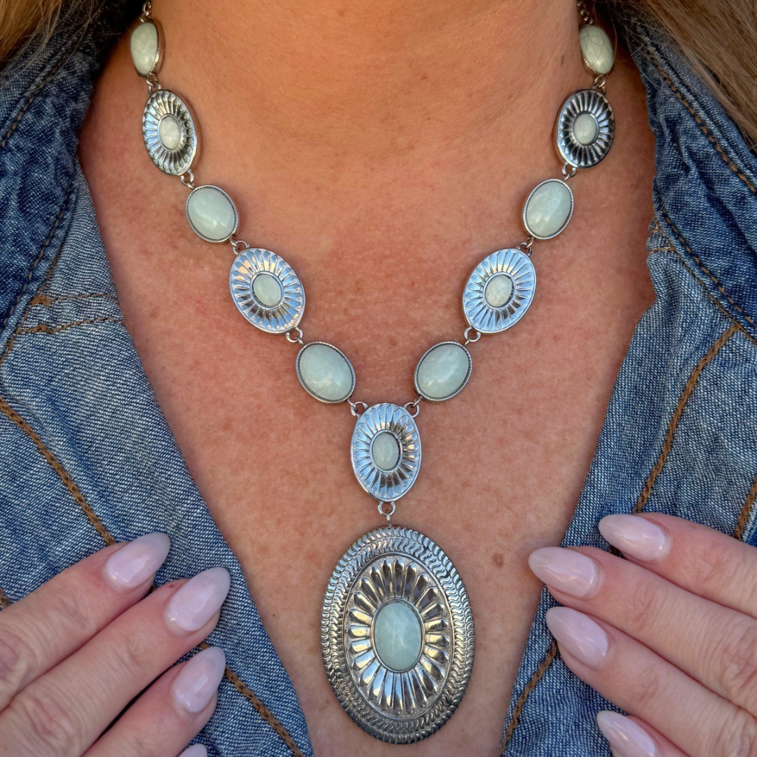 The Kathryn is a silver Western statement necklace featuring oval light-colored stones in decorative metal settings and a large oval pendant at the center.
