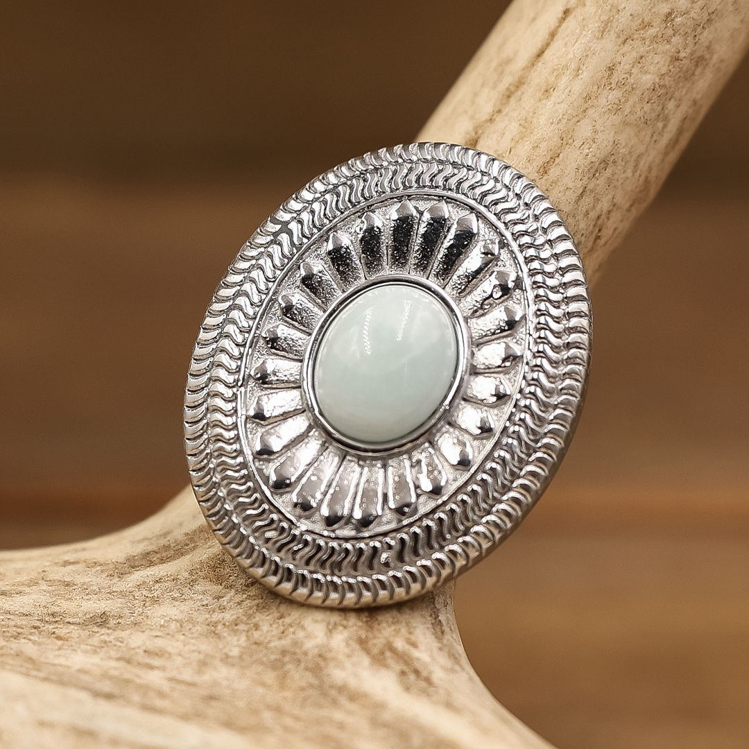 The Kathryn Ring is an oval silver-toned ring featuring a central pale green stone surrounded by an engraved Western-style sunburst pattern.
