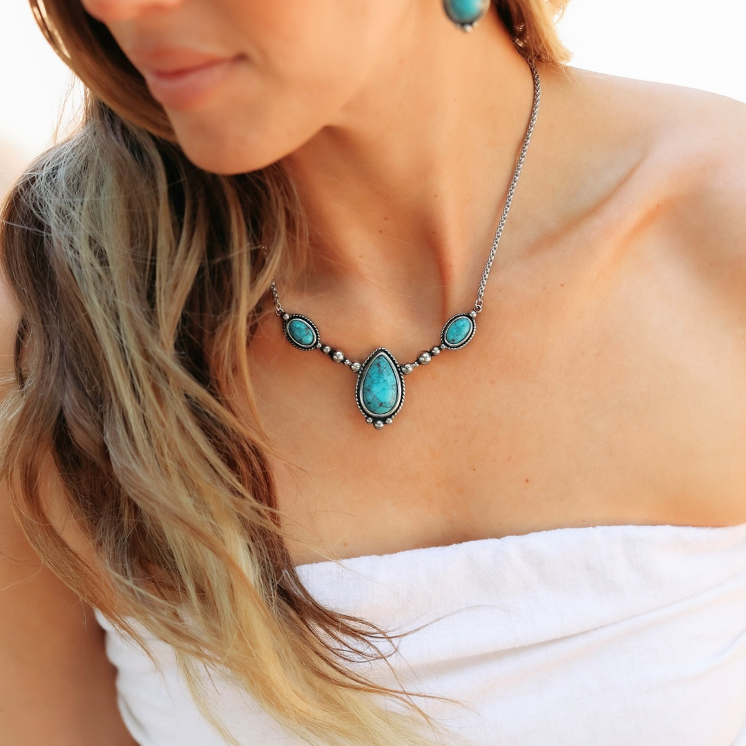 The Kay necklace in silver Western style features three teardrop-shaped turquoise stones, paired with matching earrings.