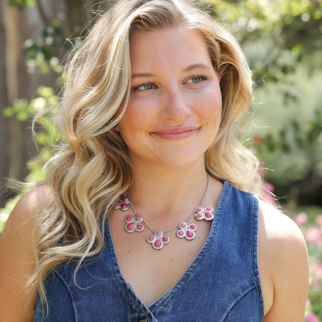 A smiling woman wearing The Prairie Rose necklace.