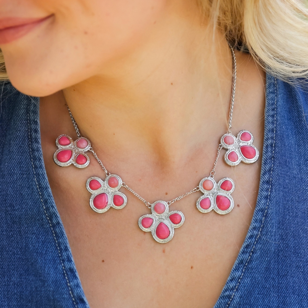 The Prairie Rose silver-tone pink statement necklace features four floral-shaped charms accented with teardrop-shaped stones.