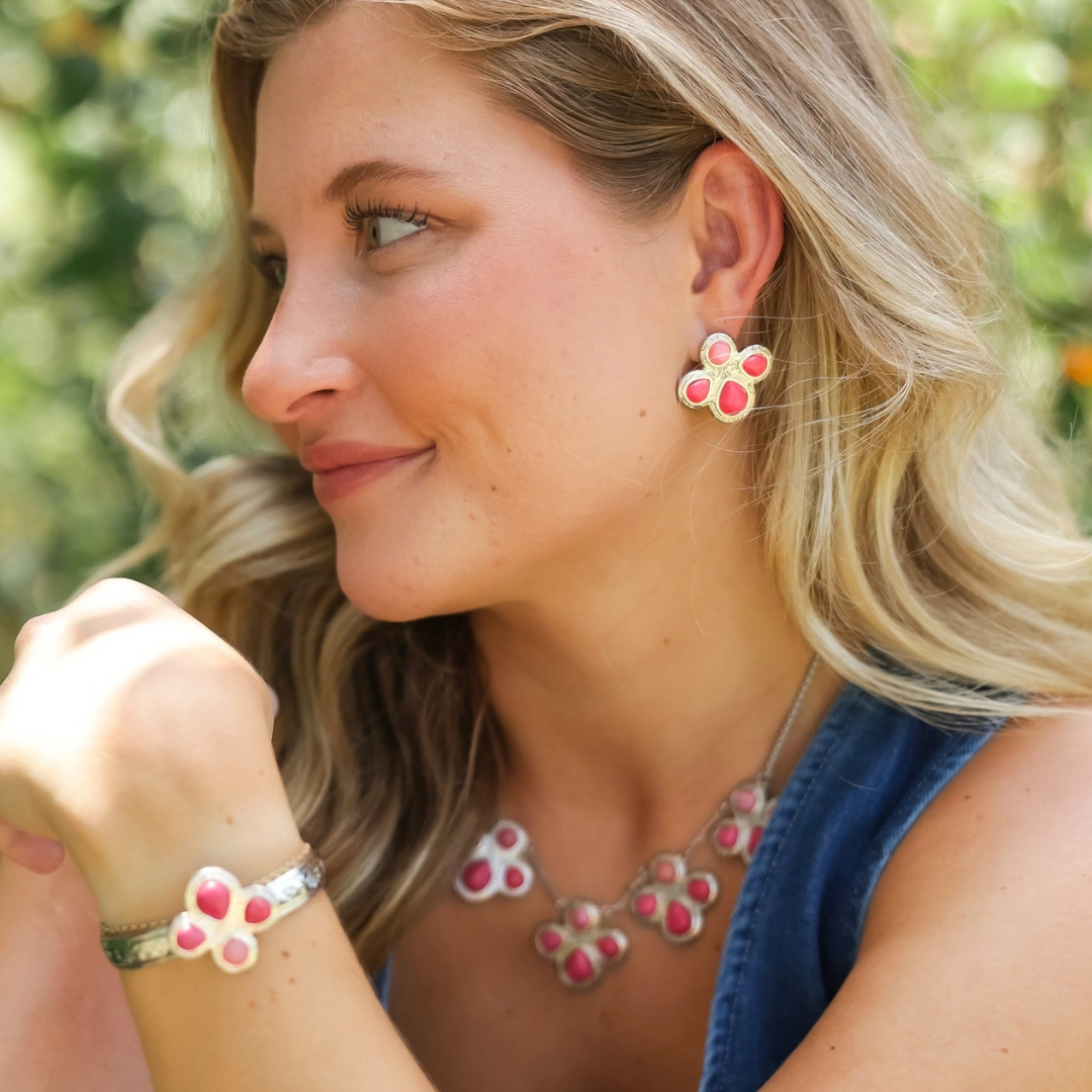 A woman wearing a matching set of Prairie Rose Studs, a necklace, and a cuff bracelet, all featuring a floral-shaped design.