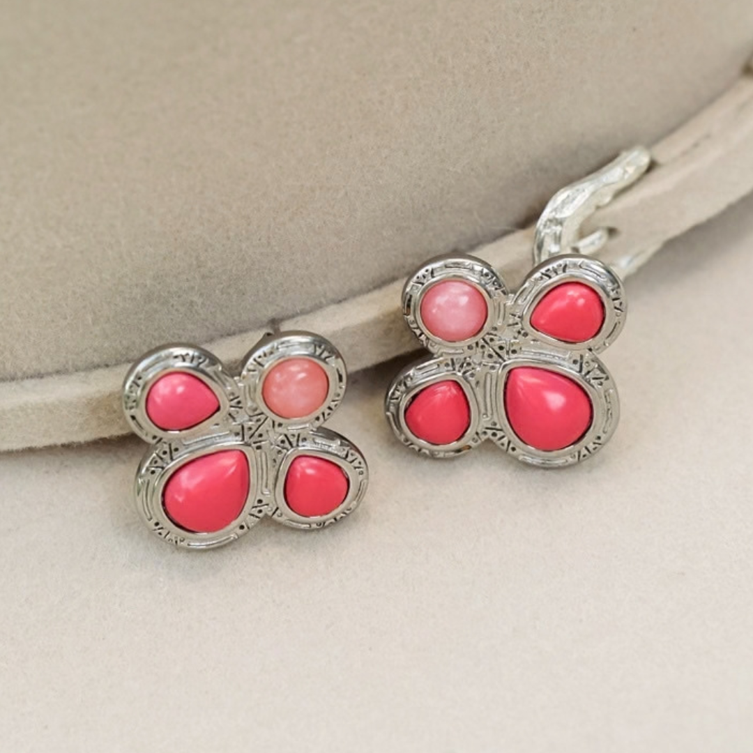 The Prairie Rose Studs are silver, flower-shaped earrings featuring pink and coral-colored stones.