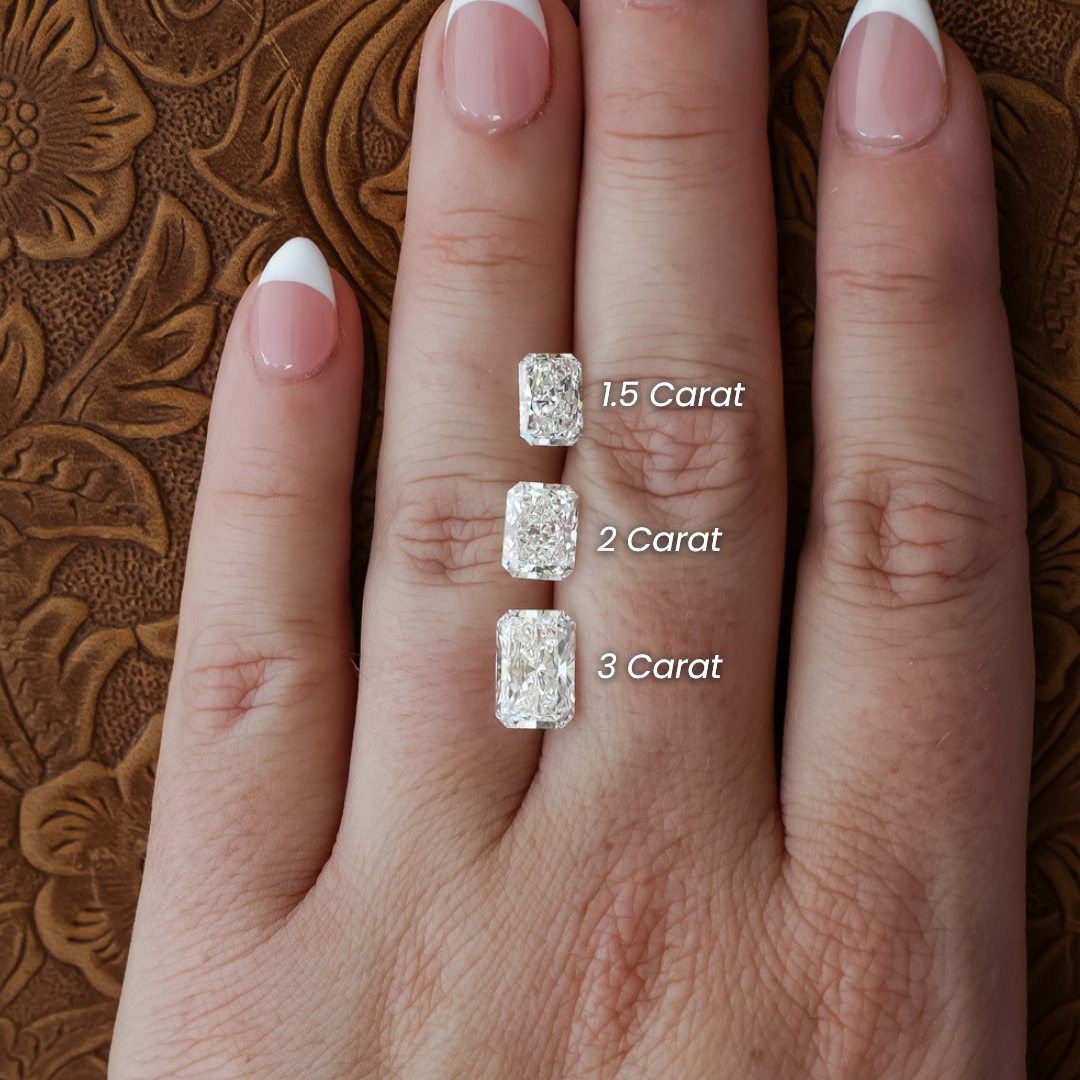 A radiant cut lab-grown diamond ring, featuring a dazzling 1.5 carat stone, is displayed on a hand with pink and white French manicured nails against a textured brown background.